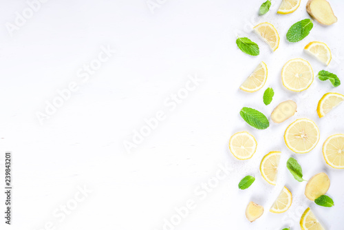 Mojito, lemonade cocktail or sour infused water ingredient. Flatlay with sliced lemon, ginger and mint leaves, layout on white background top view copy space