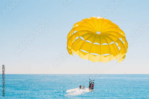 Fun pastime at sea - parasailing with people tied to a boat photo