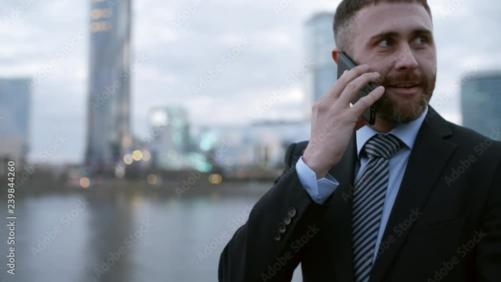 Lockdown of young Caucasian man with beard an in suit going in urban area and talking on telephone Lockdown of young Caucasian man with beard an in suit going in urban area and talking on telephone