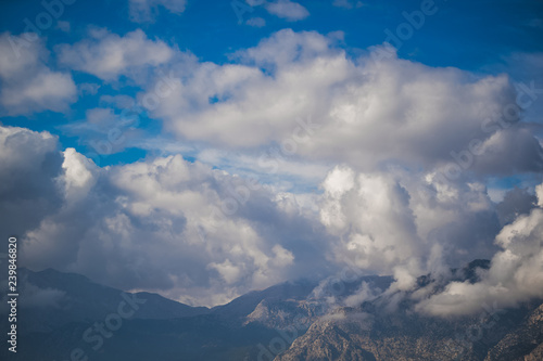 High mountain with beautiful white fluffy clouds in morning light. Amazing natural landscape. Horizontal color photography. © Andrii Oleksiienko