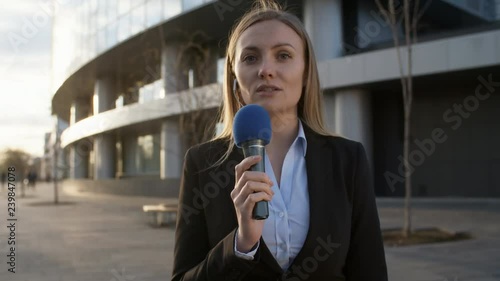 Medium shot of female Caucasian news reporter making reportage from the scene
