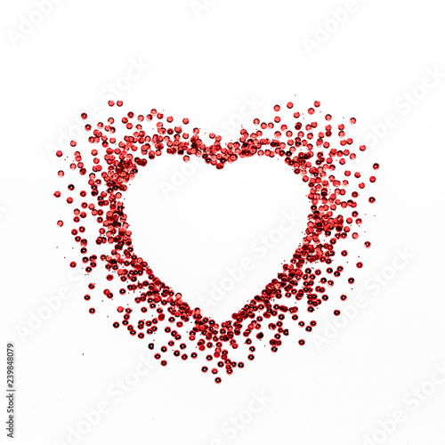 Red heart symbol on white background. Heart of glitter grains. Valentine's Day composition. lay flat, top view