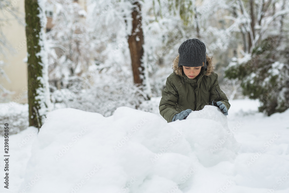 boy making snowballs outdoor in snow