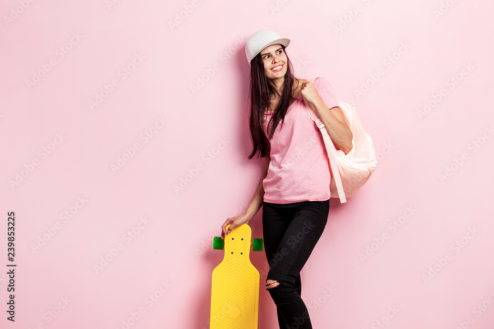 pink t-shirt and black jeans stands 