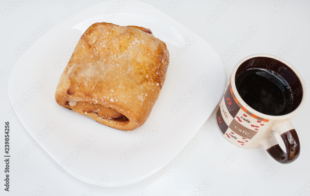 Sweet bread with guava paste filling. Served with coffee, in a white dish. Sweet bread with guava paste filling. Served with coffee, in a white dish.