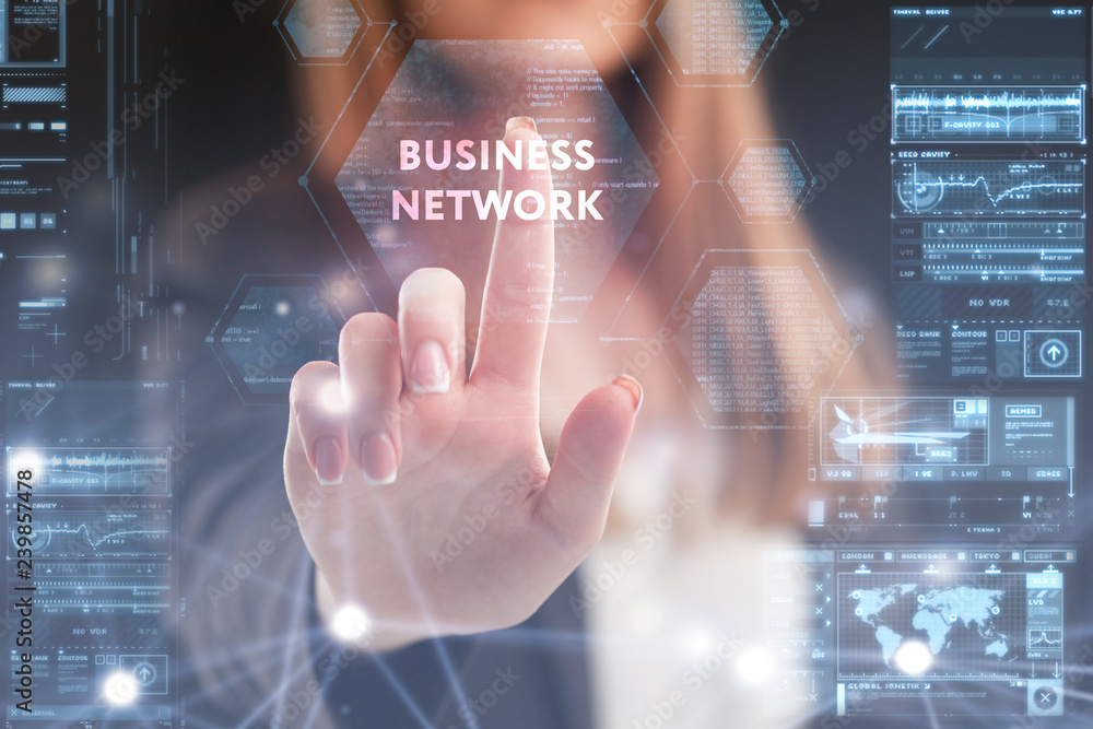 The concept of business, technology, the Internet and the network. A young entrepreneur working on a virtual screen of the future and sees the inscription: business network The concept of business, technology, the Internet and the network. A young entrepreneur working on a virtual screen of the future and sees the inscription: business network