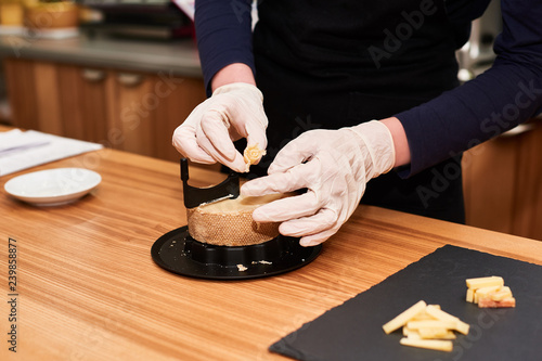 Woman cutting rosettes of Swiss monk cheese with traditional knife