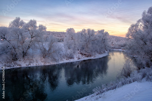 beautiful winter landscape. river with snow-covered banks in the morning at dawn