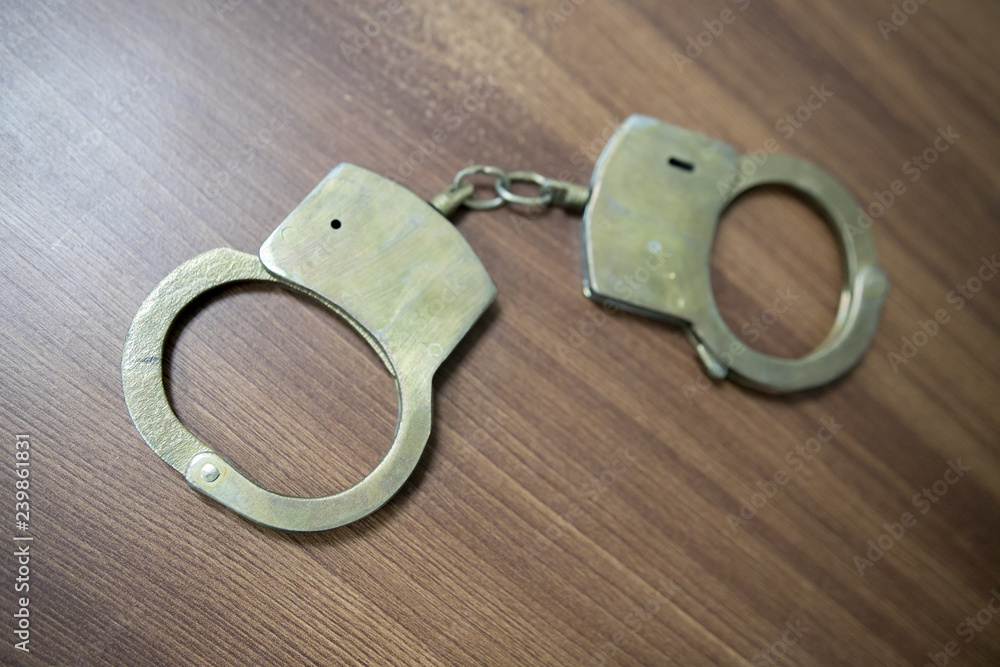 Selective focus on handcuffs on a keyboard cyber crime, hacking, bullying Against law concept in dark low key tone Selective focus on handcuffs on a keyboard cyber crime, hacking, bullying Against law concept in dark low key tone