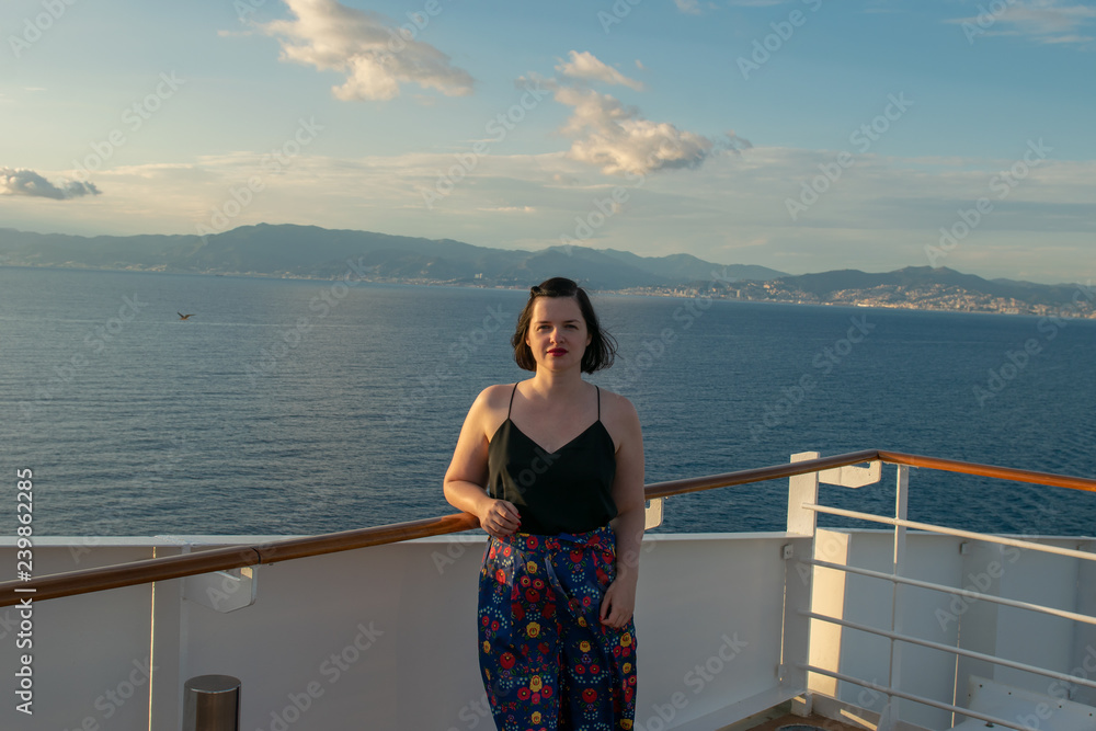 Beautiful woman enjoying the sun on a deck of a cruise ship: luxury vacation