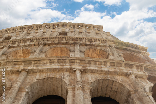 Beautiful detail of Roma Colosseum against blue sky with clouds