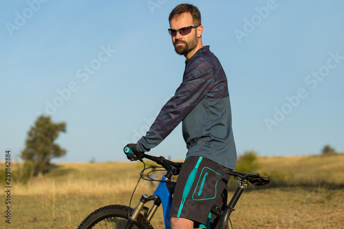 Cyclist in shorts and jersey on a modern carbon hardtail bike with an air suspension fork 
