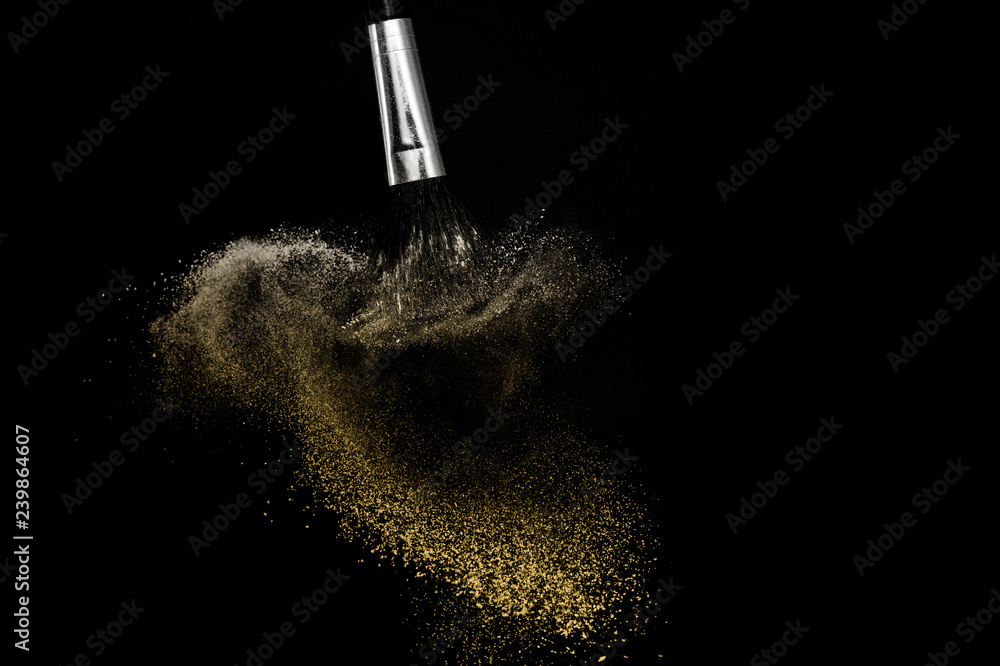 Obraz premium Cosmetic brush with golden cosmetic powder spreading for makeup artist or beauty blogger in black background, look like a luxury