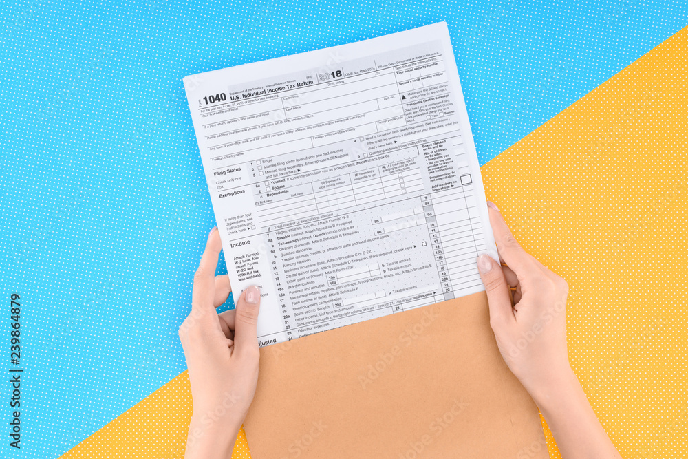 Obraz premium cropped view of woman holding tax form on blue and yellow background
