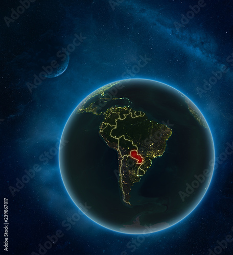 Fototapeta Naklejka Na Ścianę i Meble -  Paraguay at night from space with Moon and Milky Way. Detailed planet Earth with city lights and visible country borders.