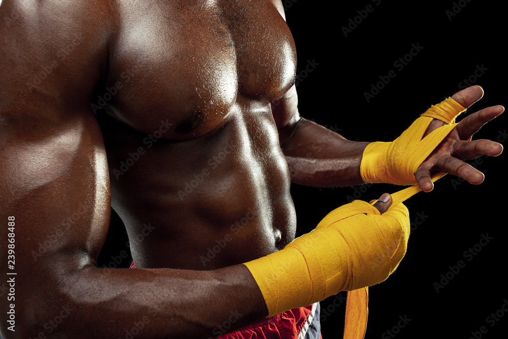 Obraz premium Afro American boxer is wrapping hands with yellow bandage