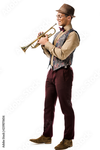 handsome young mixed race male jazzman posing with trumpet isolated on white