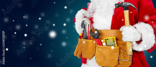 Santa Claus with a tool belt on winter background
