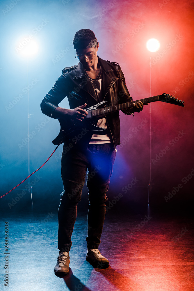 concentrated male rock star in leather jacket performing on