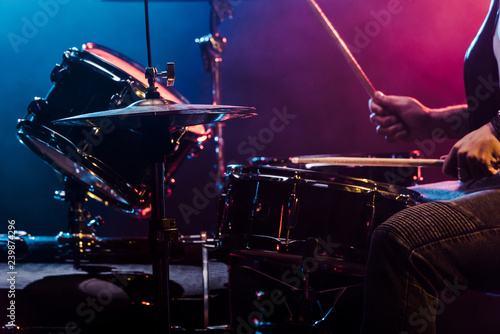 Fotografie cropped shot of male musician performing on drums during rock concert on stage