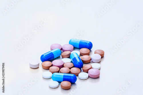 Medications of various colors on a light background.