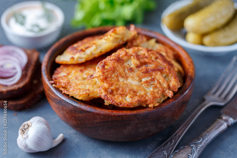 Draniki - potato fritters. potato pancakes lie on a plate. The national dish of Belarus, Ukraine, Russia. Draniki - potato fritters. potato pancakes lie on a plate. The national dish of Belarus, Ukraine, Russia.