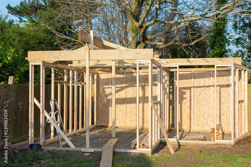 Project of wooden summer house, log cabin or shed, unfinished structure with stone base, selective focus