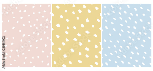 Set of 3 Cute Abstract Dots Vector Pattern. White Irregular Brush Dots on a Pink, Yellow and Blue Backgrounds. Lovely Pastel Color Delicate Layouts. Funny Infantile Style Design.