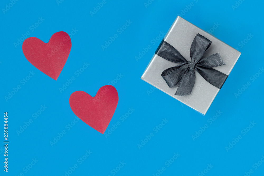 background for Valentine's day holiday, gift for Valentine's day, heart and gift box on blue background