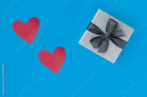 background for Valentine's day holiday, gift for Valentine's day, heart and gift box on blue background