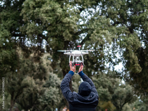 A drone landing in the hands of a man in the forest