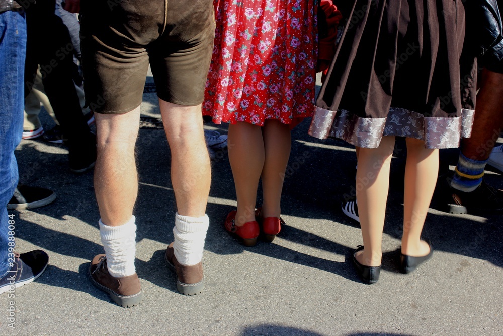 Oktoberfes impression: Man and women wearing Haferlschuh. leather trouser and dirndl dresses