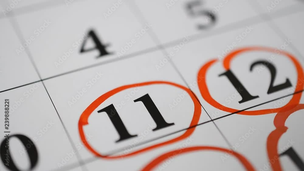 Signing a day on a calendar by red pen eleventh number Signing a day on a calendar by red pen eleventh number