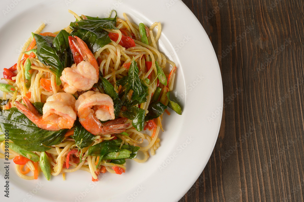 Spicy shrimp spaghetti, Asian style.On the wooden top table Spicy shrimp spaghetti, Asian style.On the wooden top table