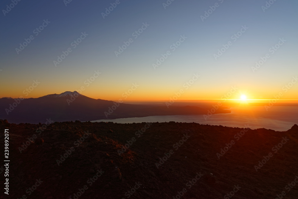 Aerial view with drone from the ski center in the volcano Osorno, Puerto Varas. With Lake Llanquihue and the Calbuco Volcano at sunset 