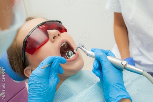 close-up medical dentist procedure of teeth polishing with cleaning from dental deposit and odontolith  photo