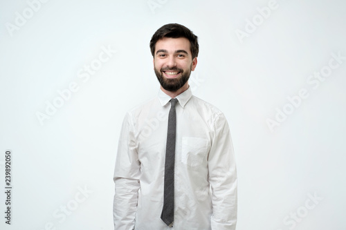 Young handsome business man over isolated background happy face smiling and looking at the camera. Positive person.