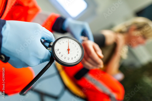 Φωτογραφία German paramedic checks the blood pressure of a patient
