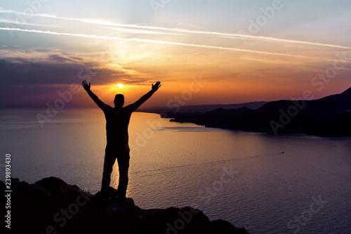 Silhouette of a man on the background of the sunset sun setting in the sea