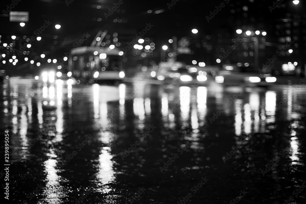 Rainy city road at night. Defocused black and white image