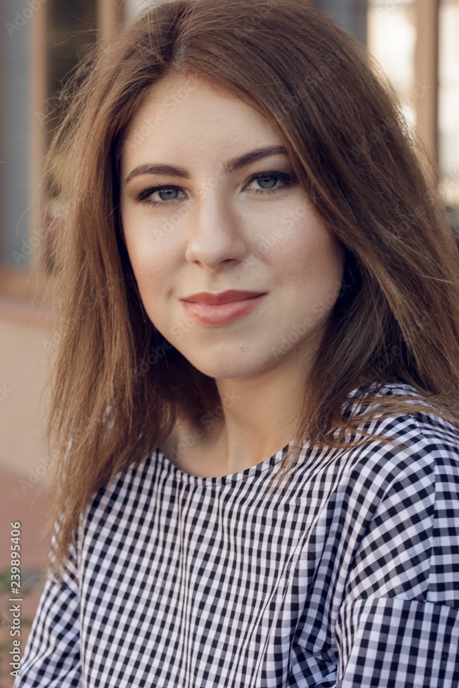 Young black woman with afro hairstyle sitting on a bench in urban background moving her legs. Mixed girl wearing casual clothes.