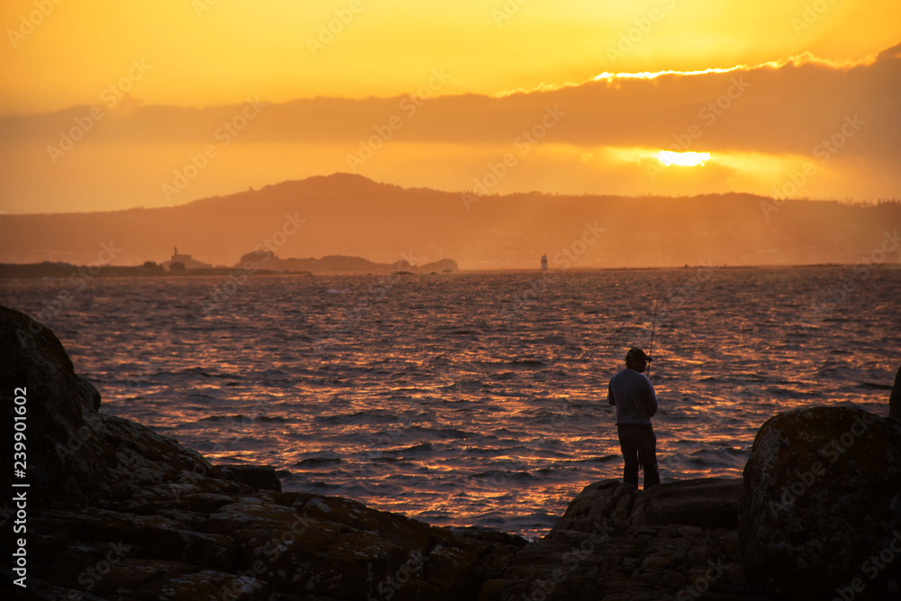 Angler fishing at sunset
