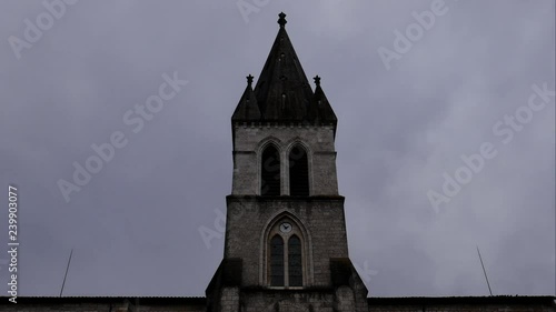 Timelapse of the peak of a small cathedral in a french village, 4K photo