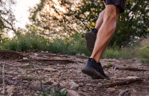 man legs running on trail in the mountains