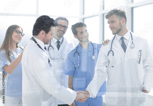 doctors shaking hands in hospital corridor