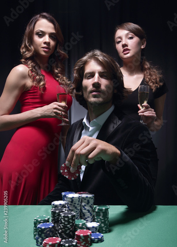 Man at roulette table surrounded by beautiful women