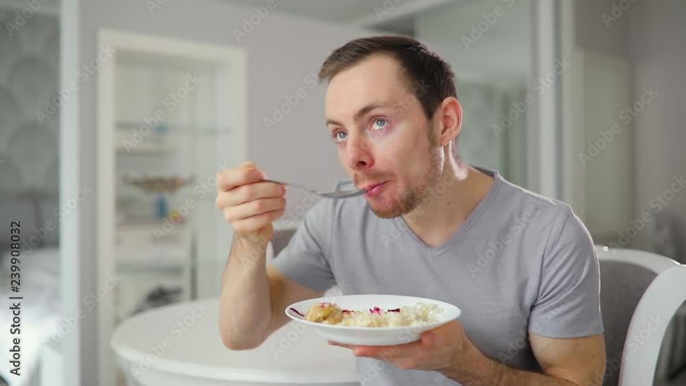 Young man eating yummy breakfast with enjoyment at home Young man eating yummy breakfast with enjoyment at home