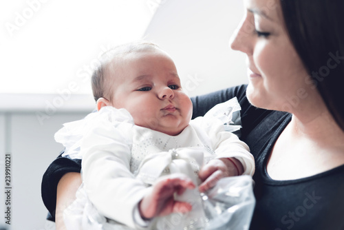 Cute baby girl in her mother's arms