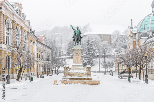 Miskolc in winter: Elisabeth square with the statue of Lajos Kossuth and the Avasi Church in the background covered in snow