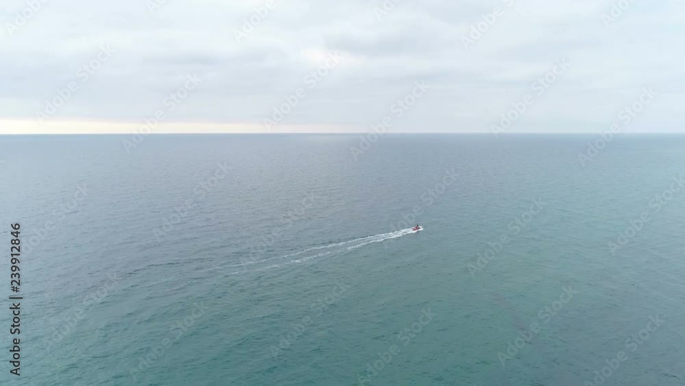 Aerial view of motor boat sailing on the sea. Green sea clear water. mountains and rocks with coastal town. Aerial view of motor boat sailing on the sea. Green sea clear water. mountains and rocks with coastal town.